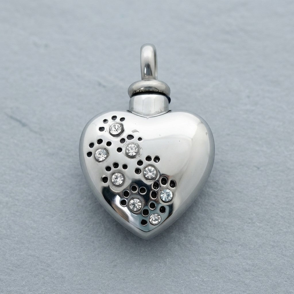 Aramat Jewels zilverkleurige stalen ashanger in hartvorm met zirkonia pootjes en perforaties.