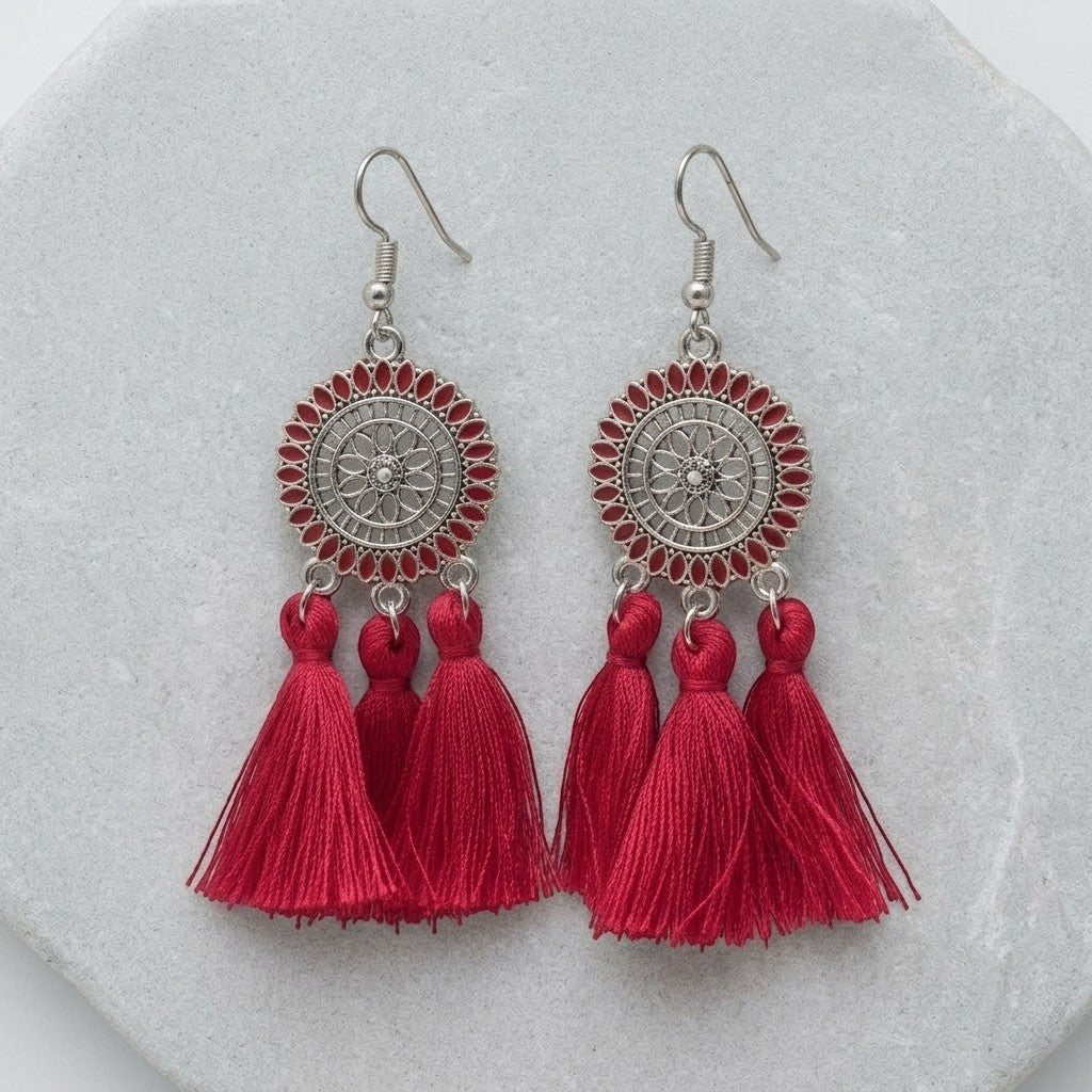 Aramat Jewels zomerse boho oorhangers met rode kwastjes en zilverkleurig metaal.