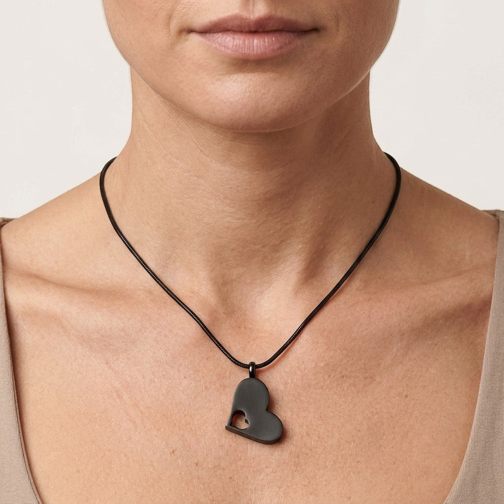 Aramat Jewels zwarte crematiehanger in hartvorm met open hart-design, gemaakt van 316L staal.