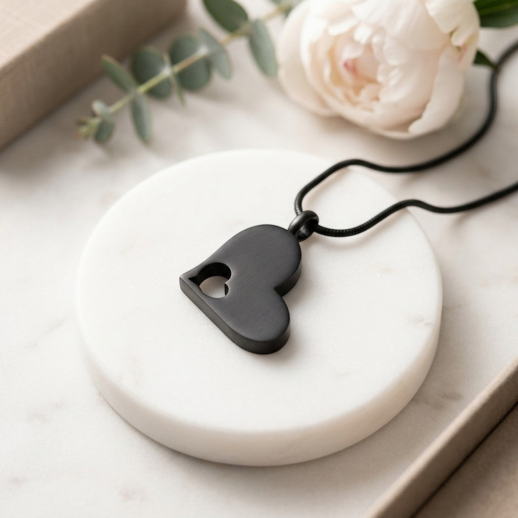 Aramat Jewels zwarte crematiehanger in hartvorm met open hart-design, gemaakt van 316L staal.