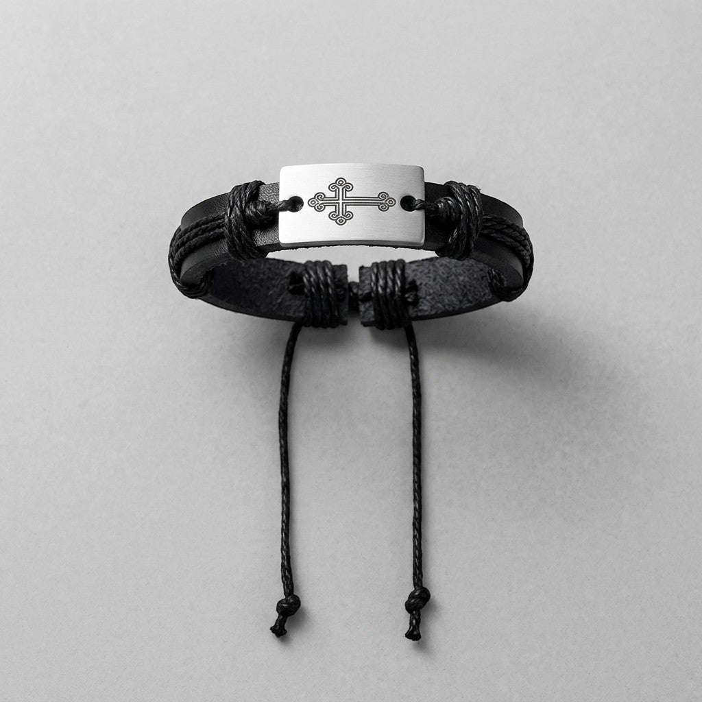Aramat Jewels zwarte lederen armband met zilverkleurig metalen plaatje voorzien van een kruis motief en koordsluiting.