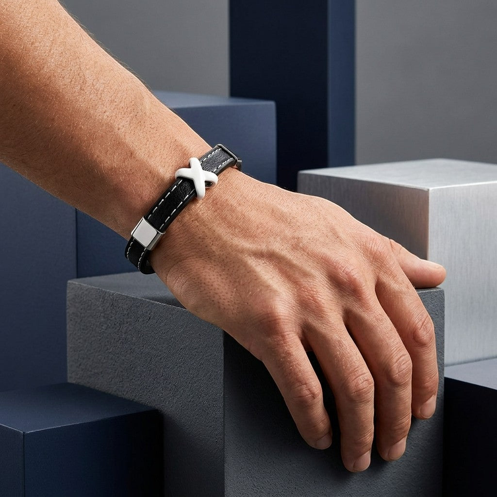 Aramat Jewels zwarte leren herenarmband met stalen kruisje, wit stiksel en RVS sluiting om een pols.