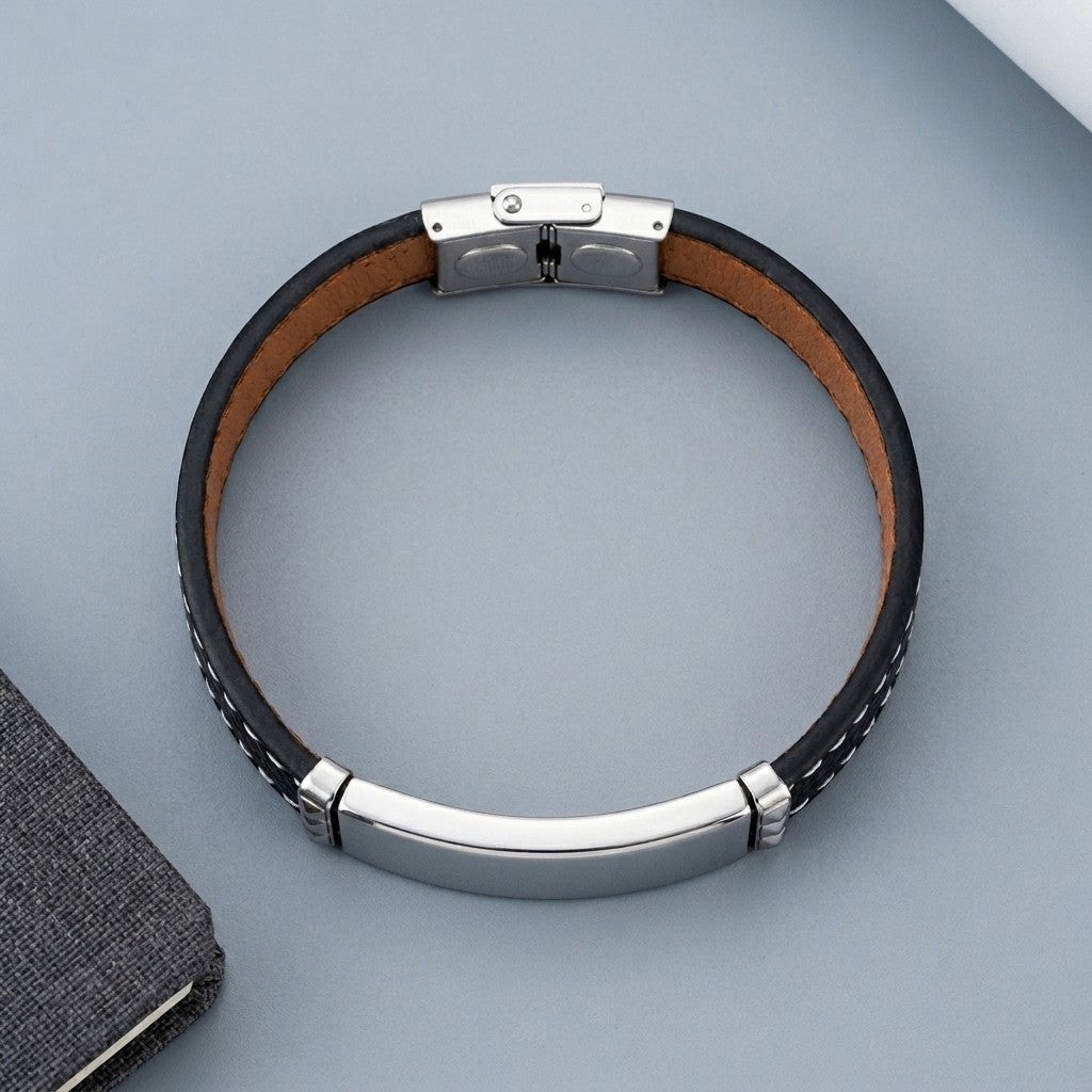 Aramat Jewels zwarte leren herenarmband met graveerbare zilverkleurige 316L RVS plaat en wit stiksel.