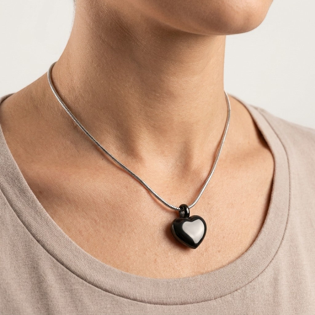 Aramat Jewels® zwarte hartvormige asbedel van 17mm roestvrij staal aan een slangenketting.
