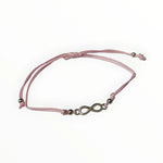 Een roze armband met een bronzen sluiting