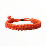 Oranje gevlochten armband met een verstelbare knoopsluiting.