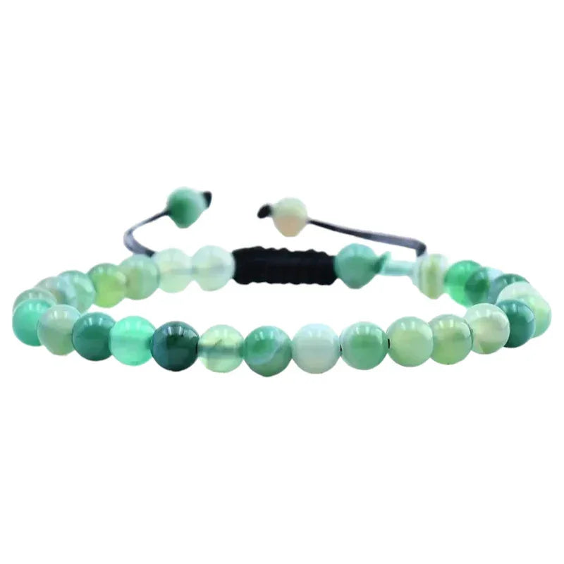 Een armband met groene jade kralen en zwart koord