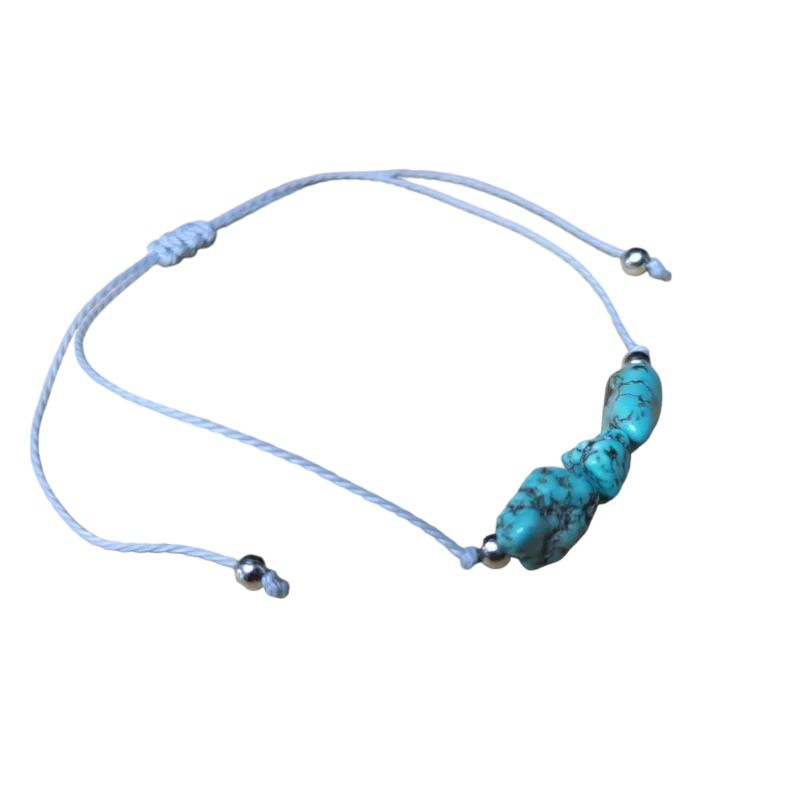 Een blauwe armband met een wit koord en een turquoise bea