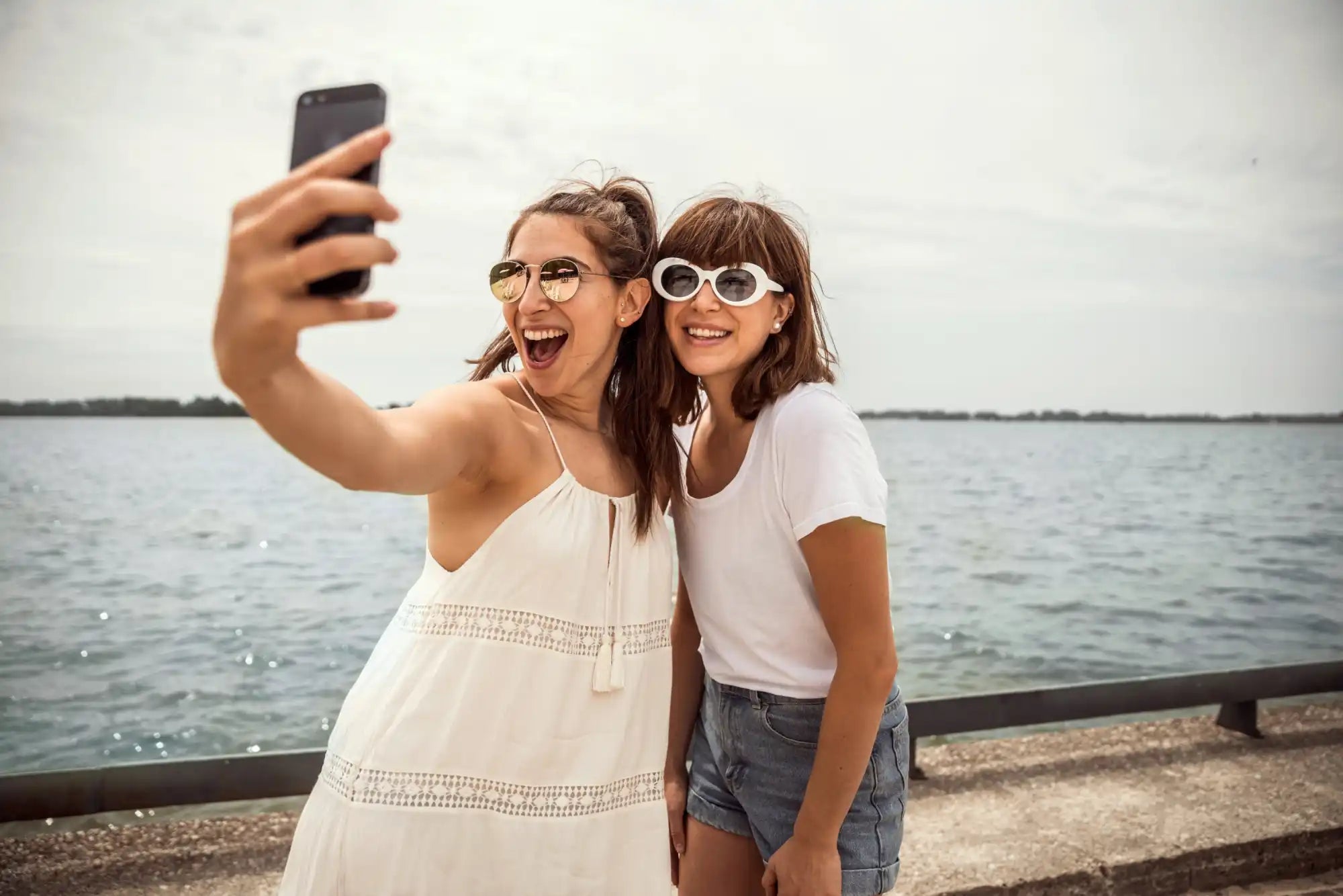 2 meisje met sieraden voor water die een selfie maken