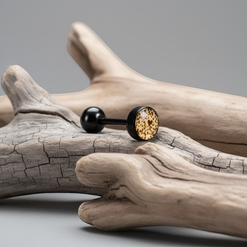 Aramat Jewels black bioplast tongue piercing with a tan and brown animal print design on the front ball.