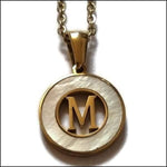 Een gouden hanger met de letter m erin