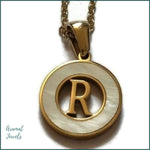 Een gouden hanger met de letter r erin