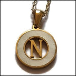 Een gouden en zilveren hanger met de letter n