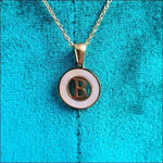 Een gouden ketting met een letter erop