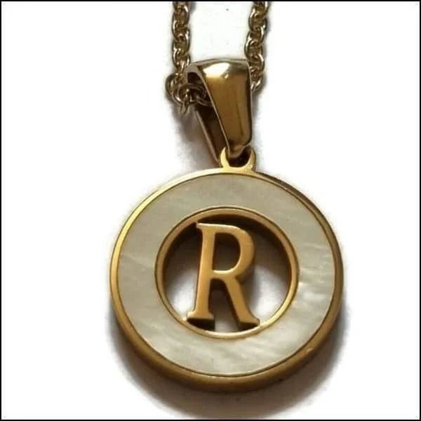 Een gouden en witte hanger met de letter r in het midden