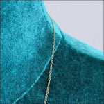 Een gouden halsketting met een kleine diamant
