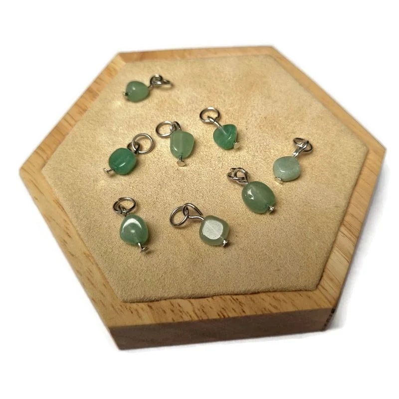 Een houten kistje met een groene jadesteen en zilveren ringen