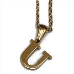 Goudkleurige Stalen Letter Ketting Van Aramat Jewels.