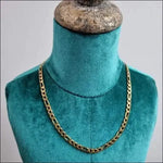 Bewerkte Goudkleurige Stalen Figaro Ketting Op Mannequin Met Gouden Ketting