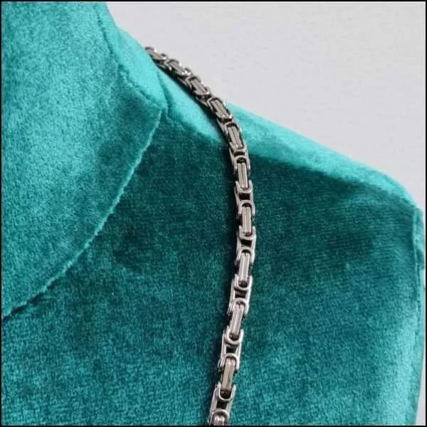 Zilverkleurige Stalen Koningsketting Van Aramat Jewels Met Close-up Van Zilveren Ketting Op Groen Shirt