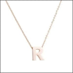 Een halsketting met witte letters en een bolletjesketting