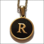 Een gouden en zwarte hanger met de letter r