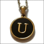 Een gouden en zwarte hanger met de letter u