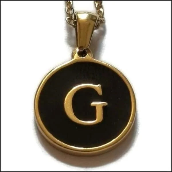 Een gouden en zwarte hanger met de letter g