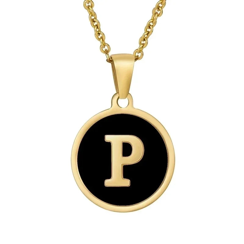 Hanger met vergulde ketting met de letter ’P’ op een zwarte ronde achtergrond.