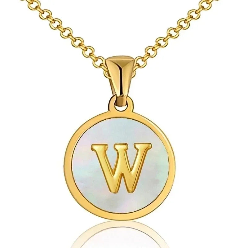 Hanger met vergulde ketting met de letter ’W’ op een parelachtige achtergrond.