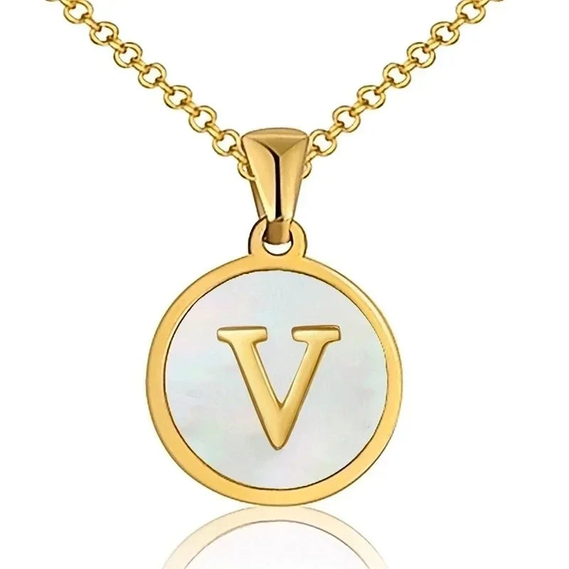 Hanger met vergulde ketting met de letter ’V’ op een witte ronde achtergrond.