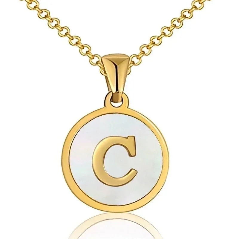 Gouden en witte ronde hanger met de letter ’C’ aan een ketting.