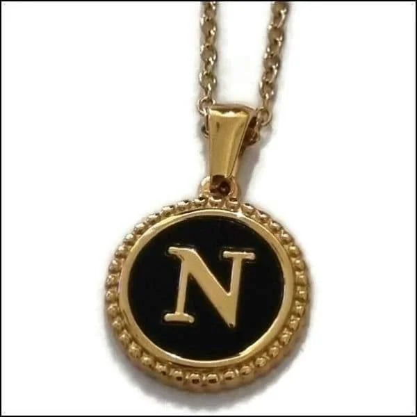 Een gouden ketting met een zwarte letter n