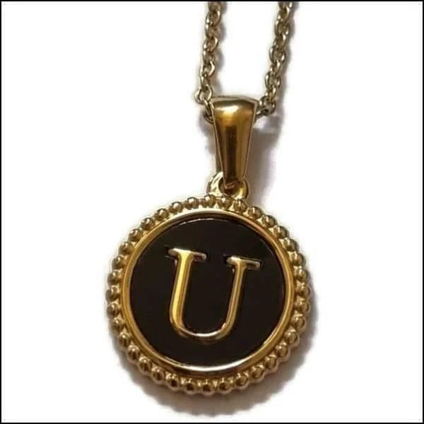 Een gouden ketting met een zwarte letter u erop