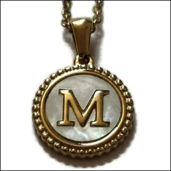 Een gouden hanger met de letter m erin