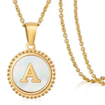 Hanger met vergulde ketting met de letter ’A’ op een parelmoeren achtergrond met kralenrand.