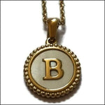 Een gouden hanger met de letter b erop