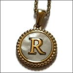 Een gouden en zilveren hanger met de letter r