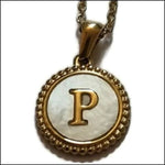 Een gouden hanger met een letter p erop