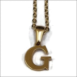 Een gouden hanger met de letter g erop