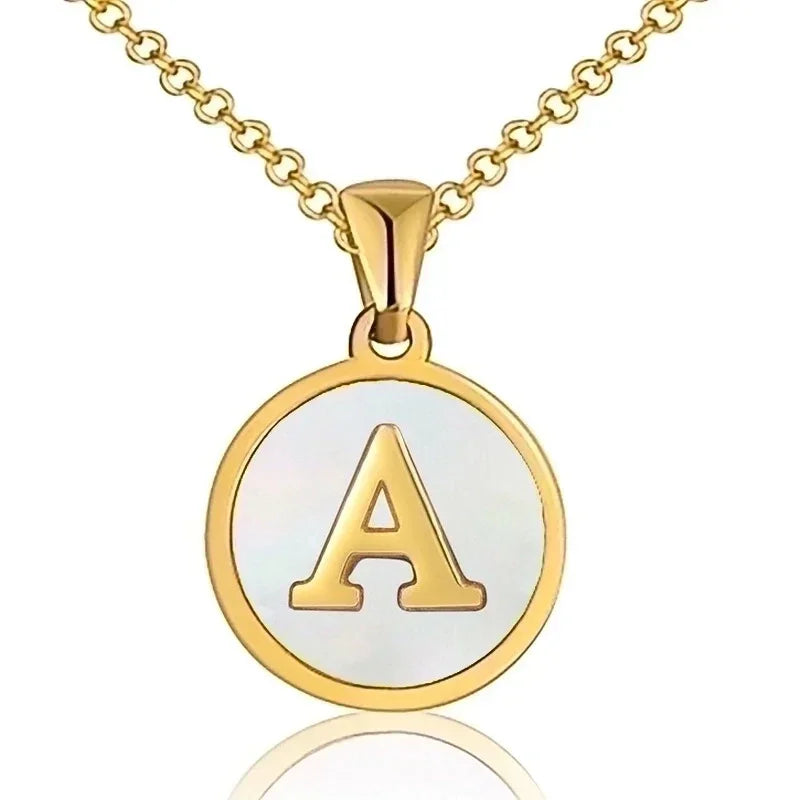 Hanger met vergulde ketting met de letter ’A’ op een witte ronde achtergrond.