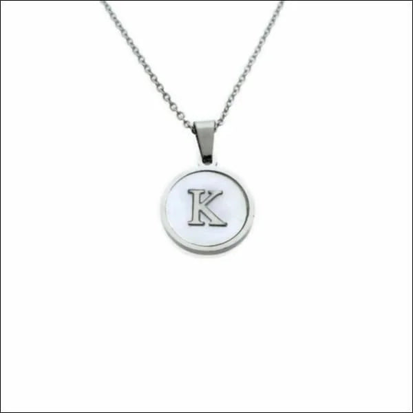 Een zilveren ketting met een witte letter k erop