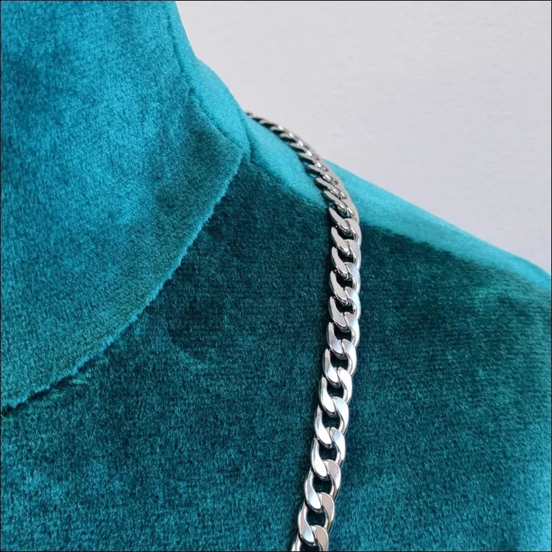 Een close-up van een zilveren ketting op een blauw shirt