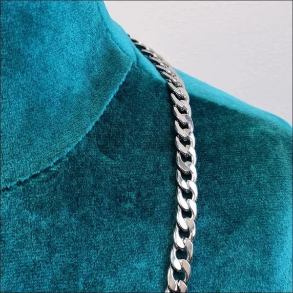 Een close-up van een zilveren ketting op een blauwe jurk