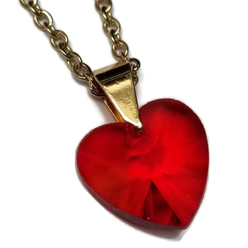 Een hanger met een rood hart en een gouden ketting