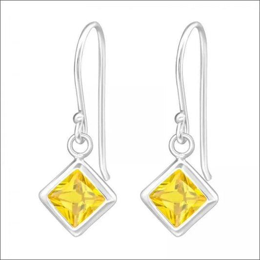 Een paar oorbellen met een vierkant geslepen geel kristal