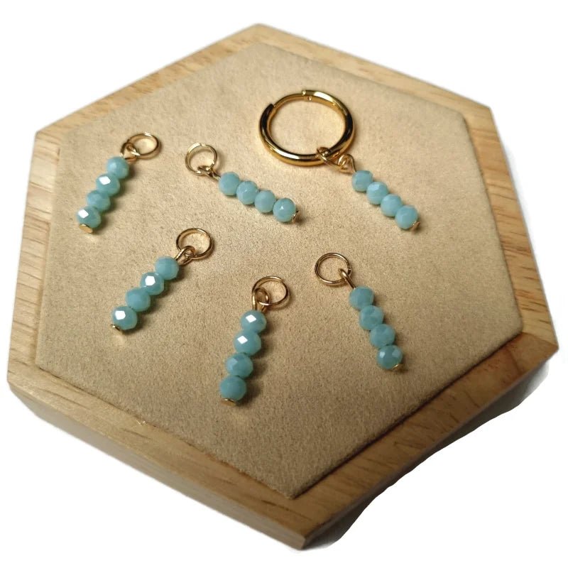 Een houten doos met drie ringen en een kleine blauwe bea