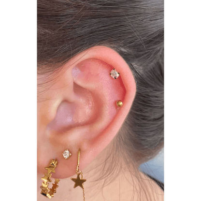 Een vrouw met een gouden ster oorpiercing