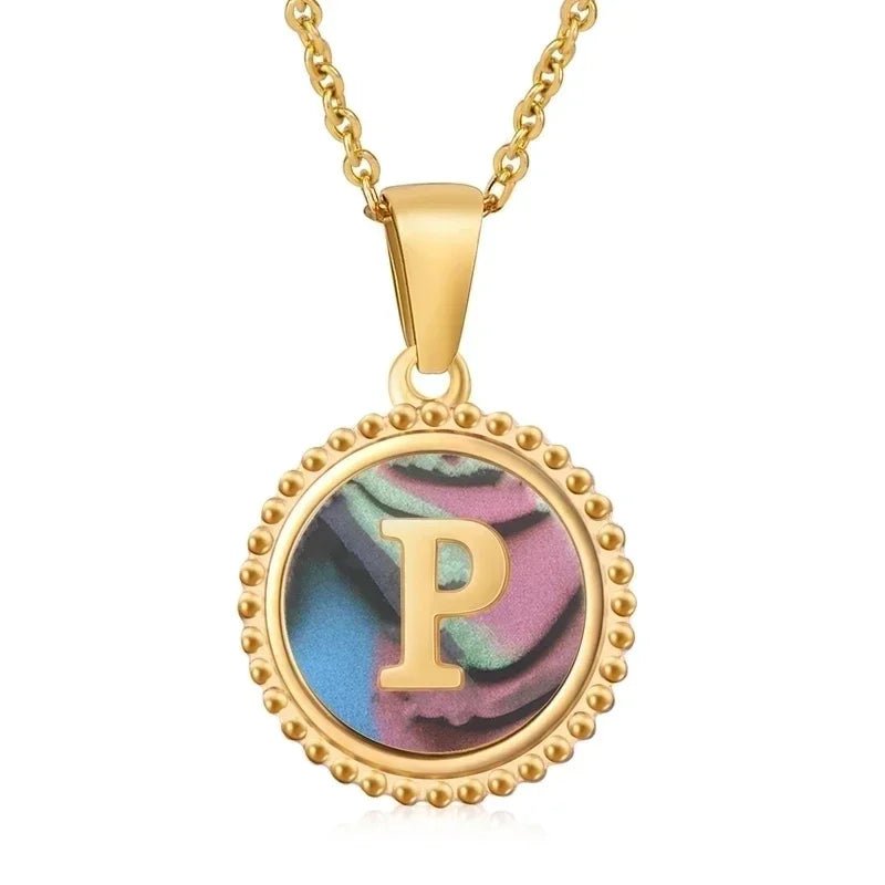 Hanger met vergulde ketting met de letter ’P’ op een iriserende achtergrond met kralenrand.