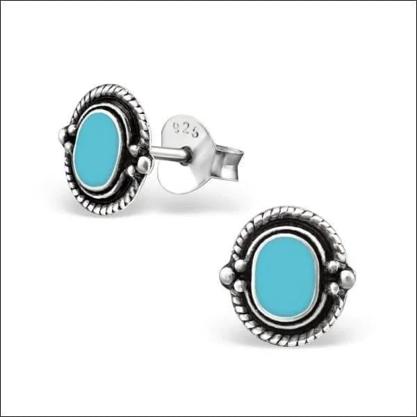 Een paar turquoise oorbellen met zilveren knopjes